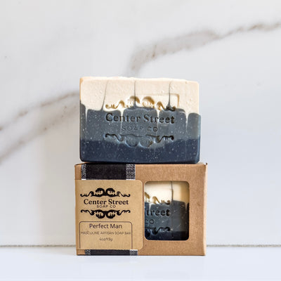 Pair of 'Perfect Man' handmade soap bars packaged in a kraft box, displayed on a marble surface